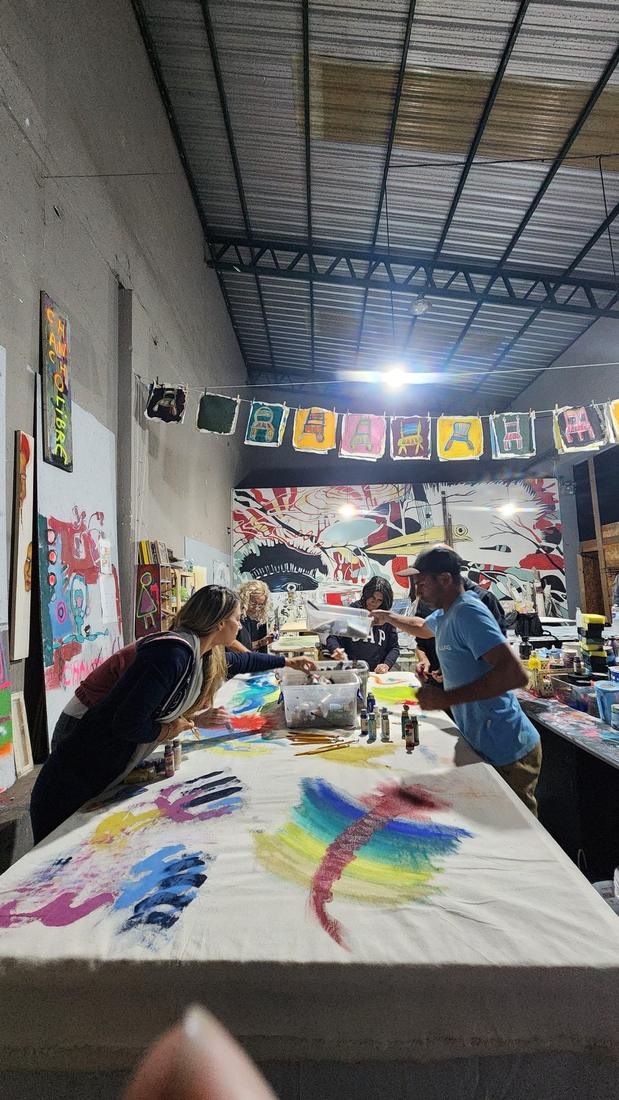 El taller en Tigre: mesas de trabajo, telas y obra colgada